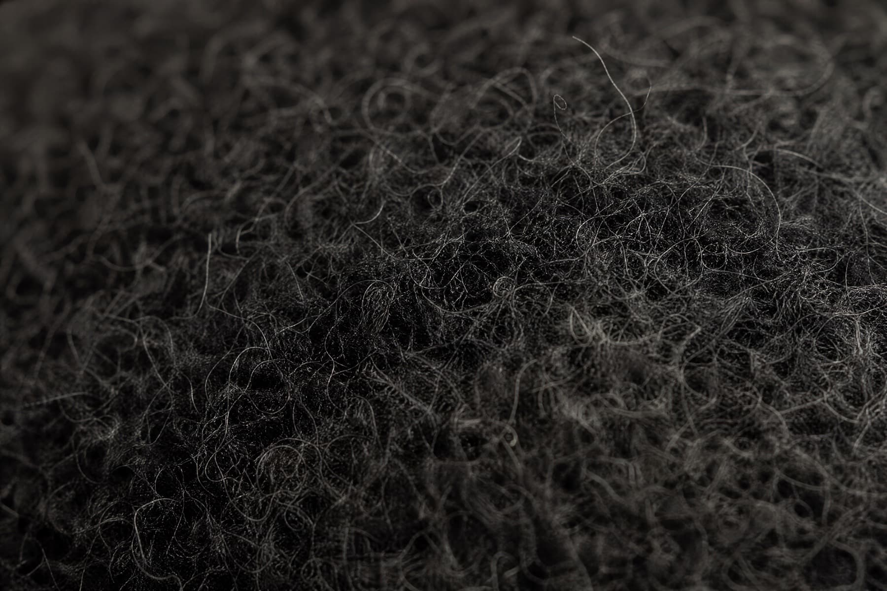 Macro of wool felt showing coarse fibres matted and interlaced in every direction