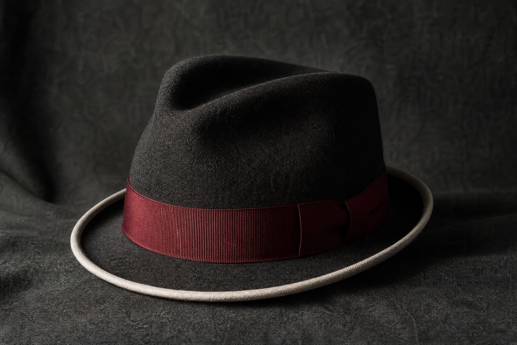Trilby Rabbit: charcoal felt hat photographed whole under a single hard side light