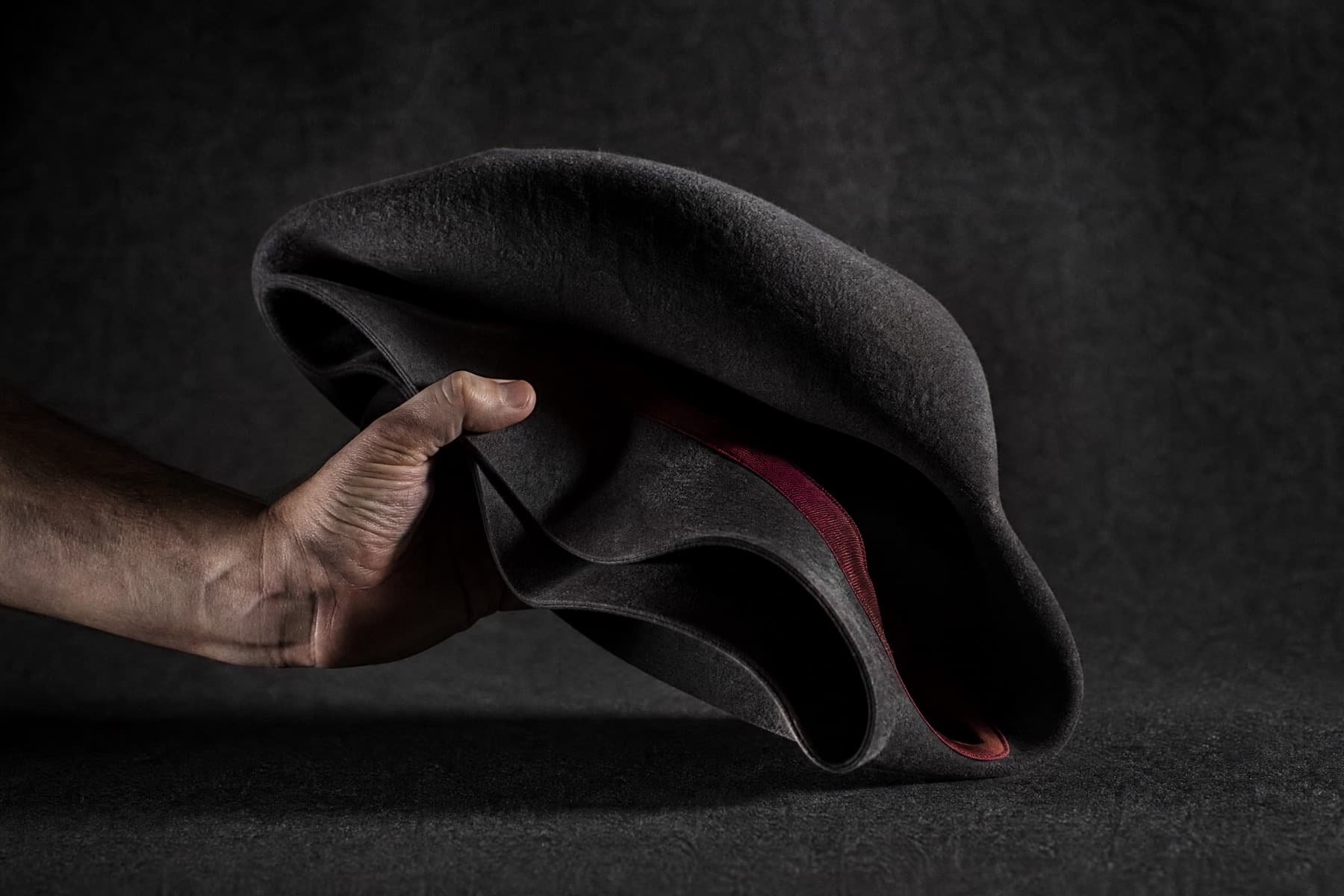 Packable Rabbit: charcoal felt hat photographed whole under a single hard side light